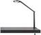 Elegante schwarze Tischlampe mit flexiblem Arm und rundem Leuchtkopf, montiert auf einem modernen dunklen Tisch.