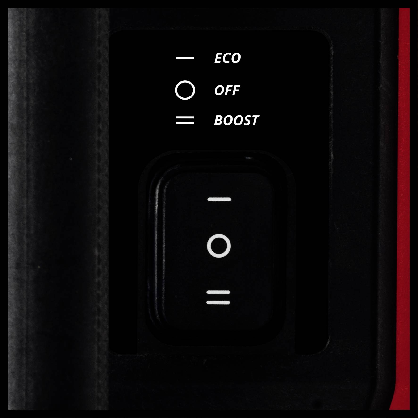 Schalter mit drei Positionen: 'ECO', 'OFF' und 'BOOST'. Schwarzer Hintergrund mit weißer Schrift. Hauptbedienelement eines Geräts.