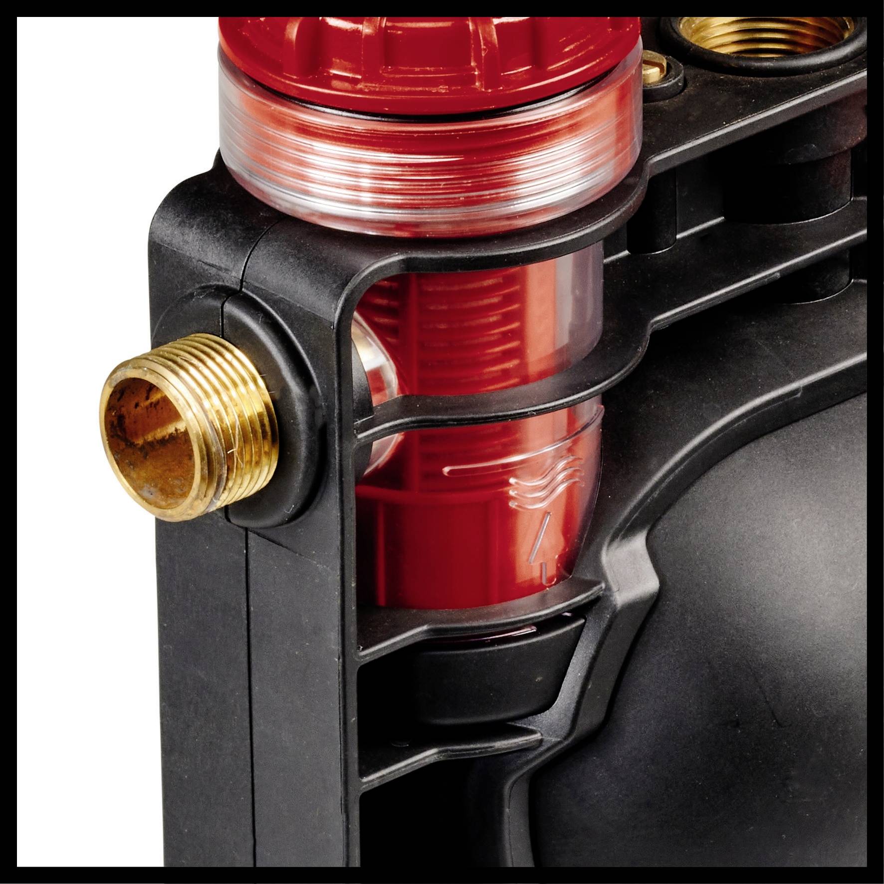 Ein rotes, technisches Bauteil mit einem transparenten, zylindrischen Bereich und messingfarbenem Anschluss, Teil einer Maschinenkomponente.