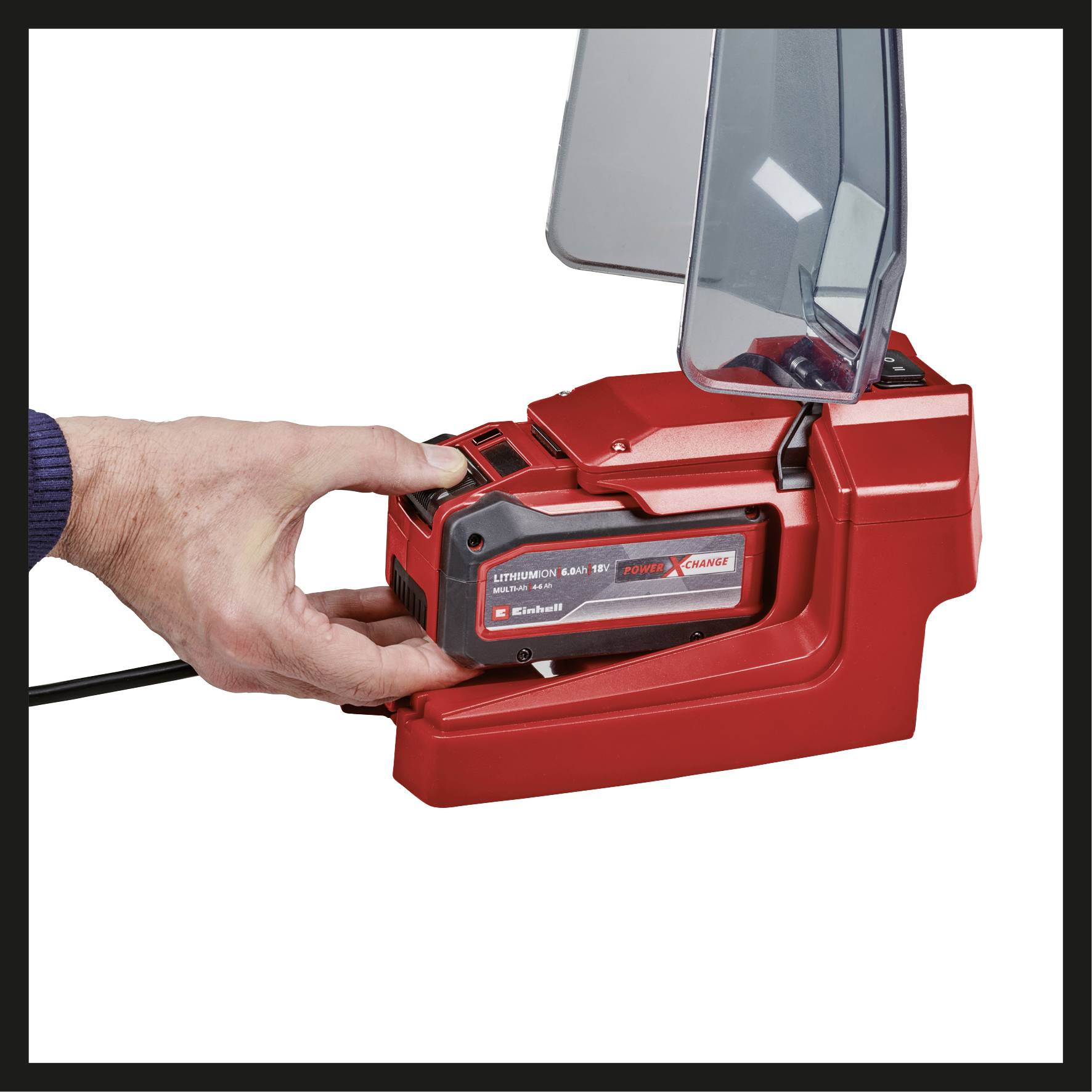 Eine Hand setzt einen wiederaufladbaren Lithium-Ionen-Akku in ein rotes Ladegerät ein.