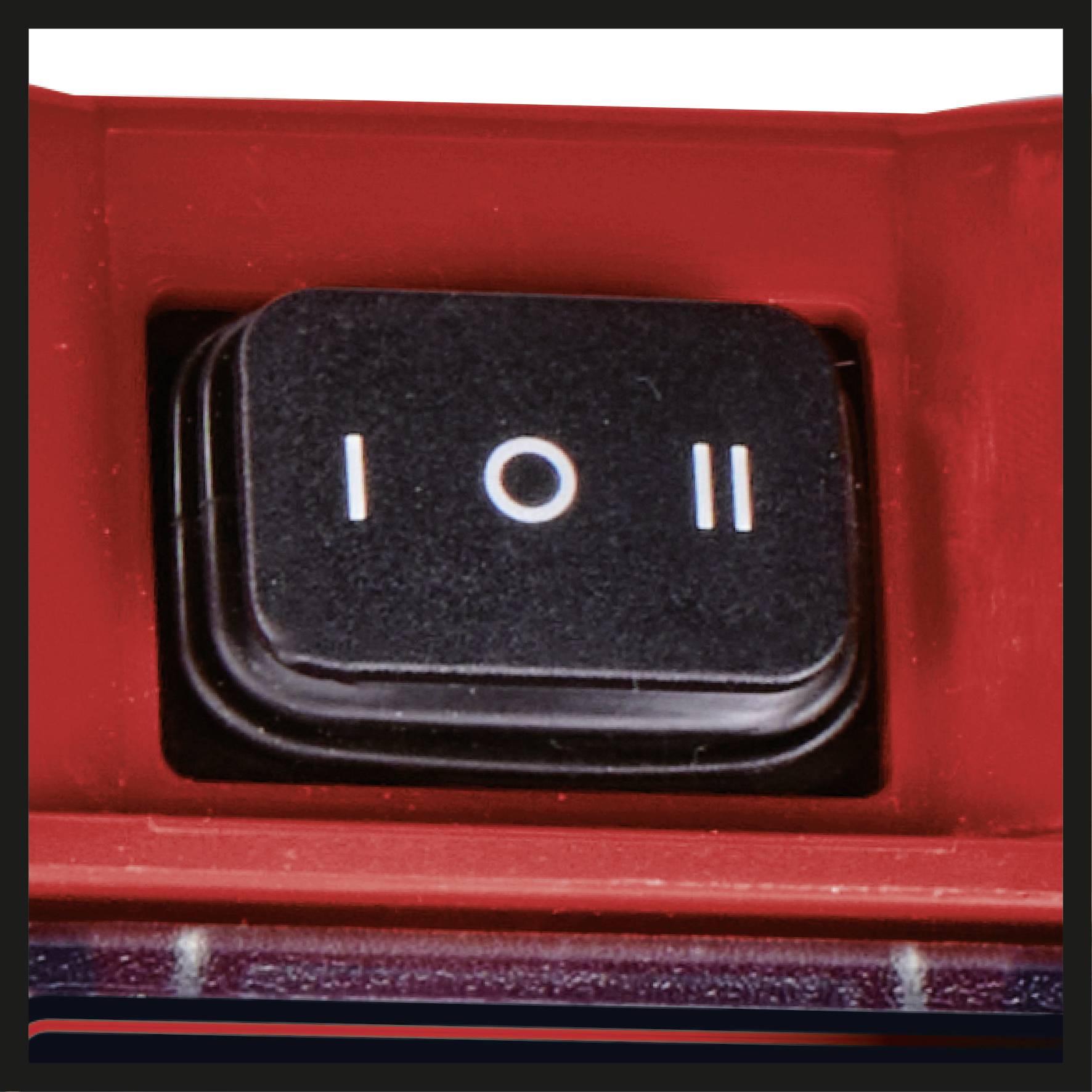 Ein roter Schalter mit drei Positionen: eingeschaltet (I), aus (O) und pausiert (II), eingebaut in ein Gerät.