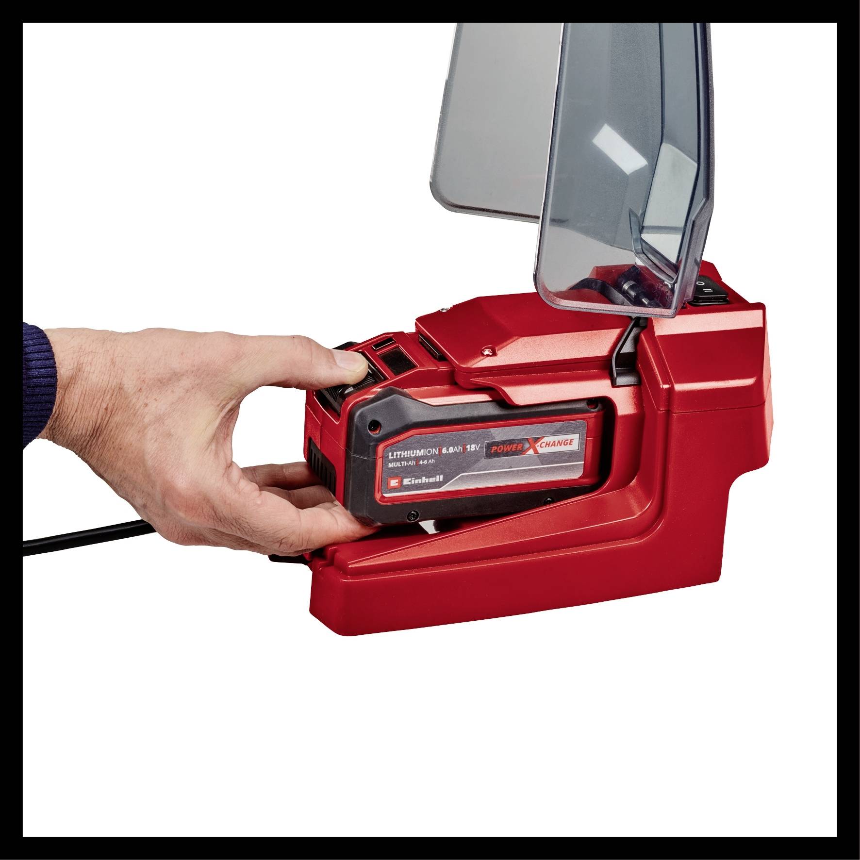 Eine Hand hält einen roten Akkulader mit einem schwarzen Akku, der in die Ladeeinheit eingesetzt wird.