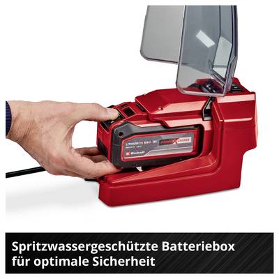 Hand legt einen Akku in eine rote Batterieladebox mit Klappdeckel; unten steht 'Spritzwassergeschützte Batteriebbox für optimale Sicherheit'.