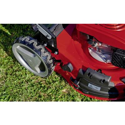 Ein roter Rasenmäher steht auf grünem Gras. Große, profilierte Räder und ein Motorgehäuse sind sichtbar.