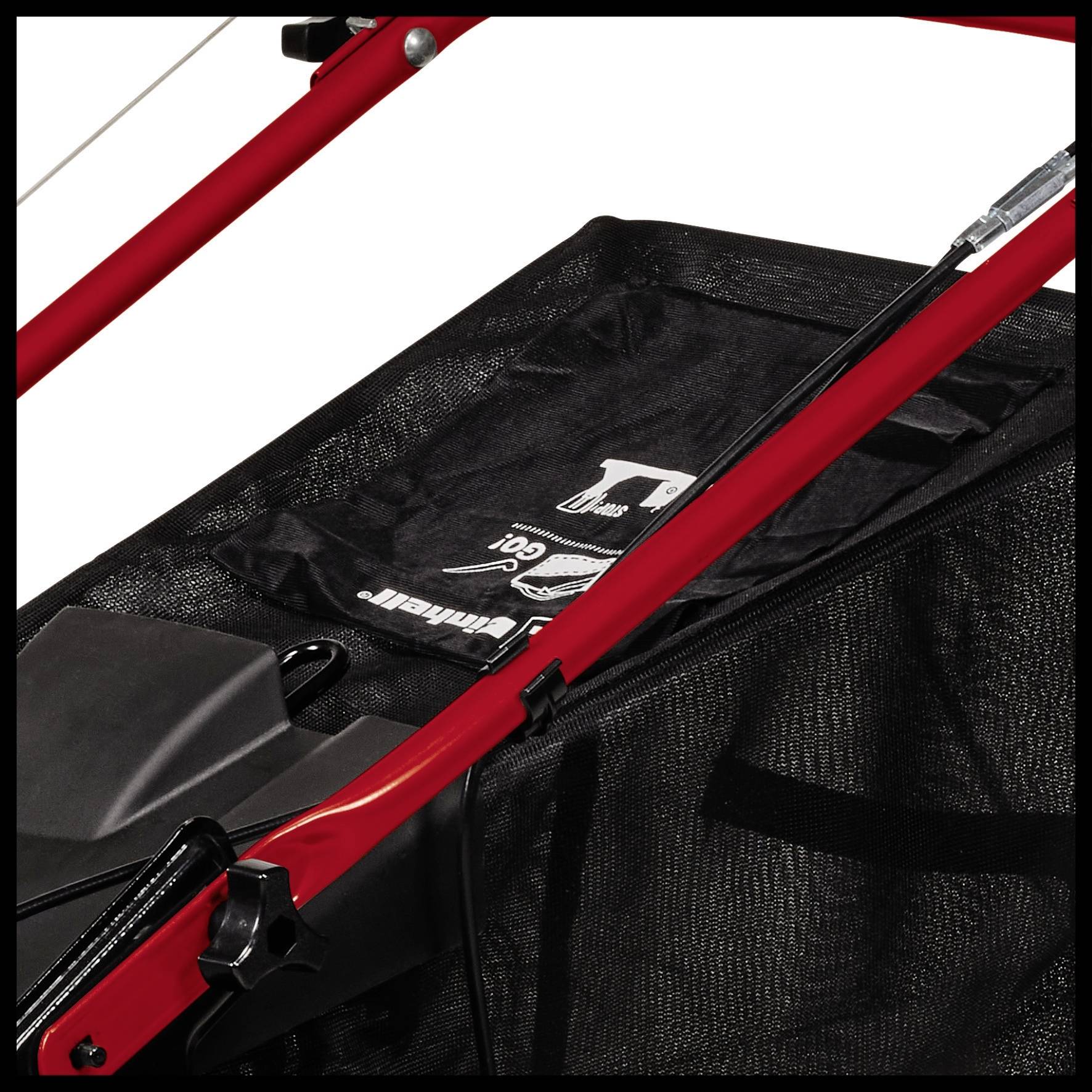 Nahaufnahme eines Teils eines Rasenmähers mit rotem Rahmen und schwarzem Grasfangsack.