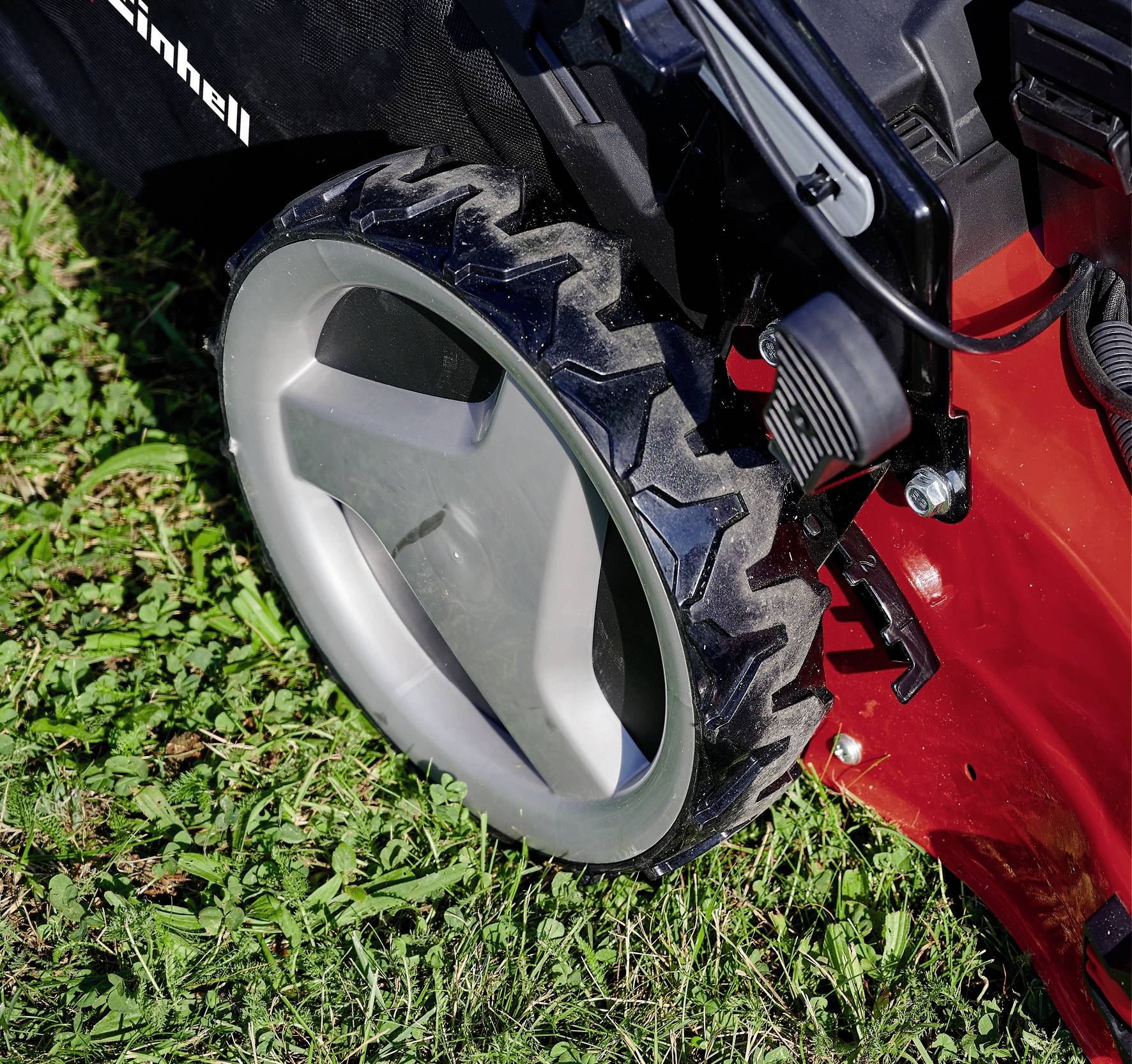 Rasenmäher-Rad auf Gras, Nahaufnahme. 