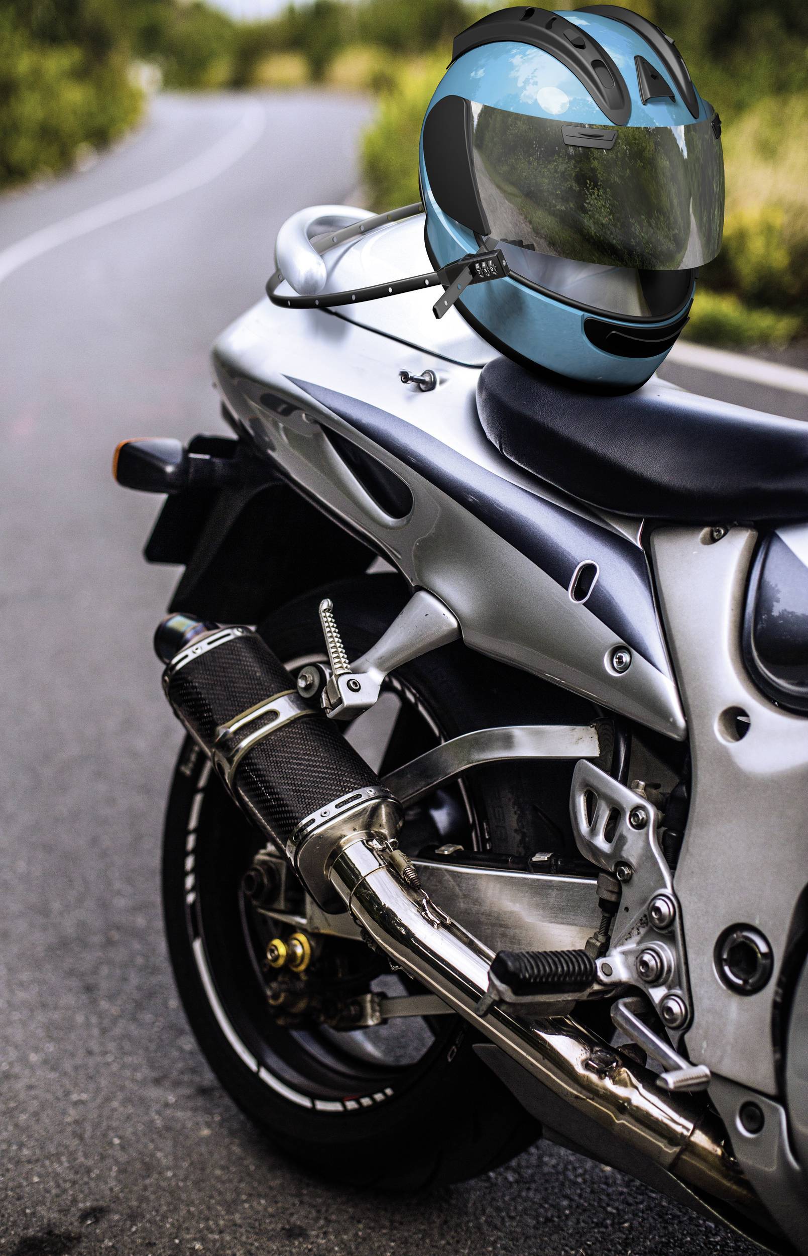 Motorrad auf einer Landstraße mit einem blauen Helm auf dem Sitz. Hintergrund zeigt eine kurvige Straße und grüne Vegetation.