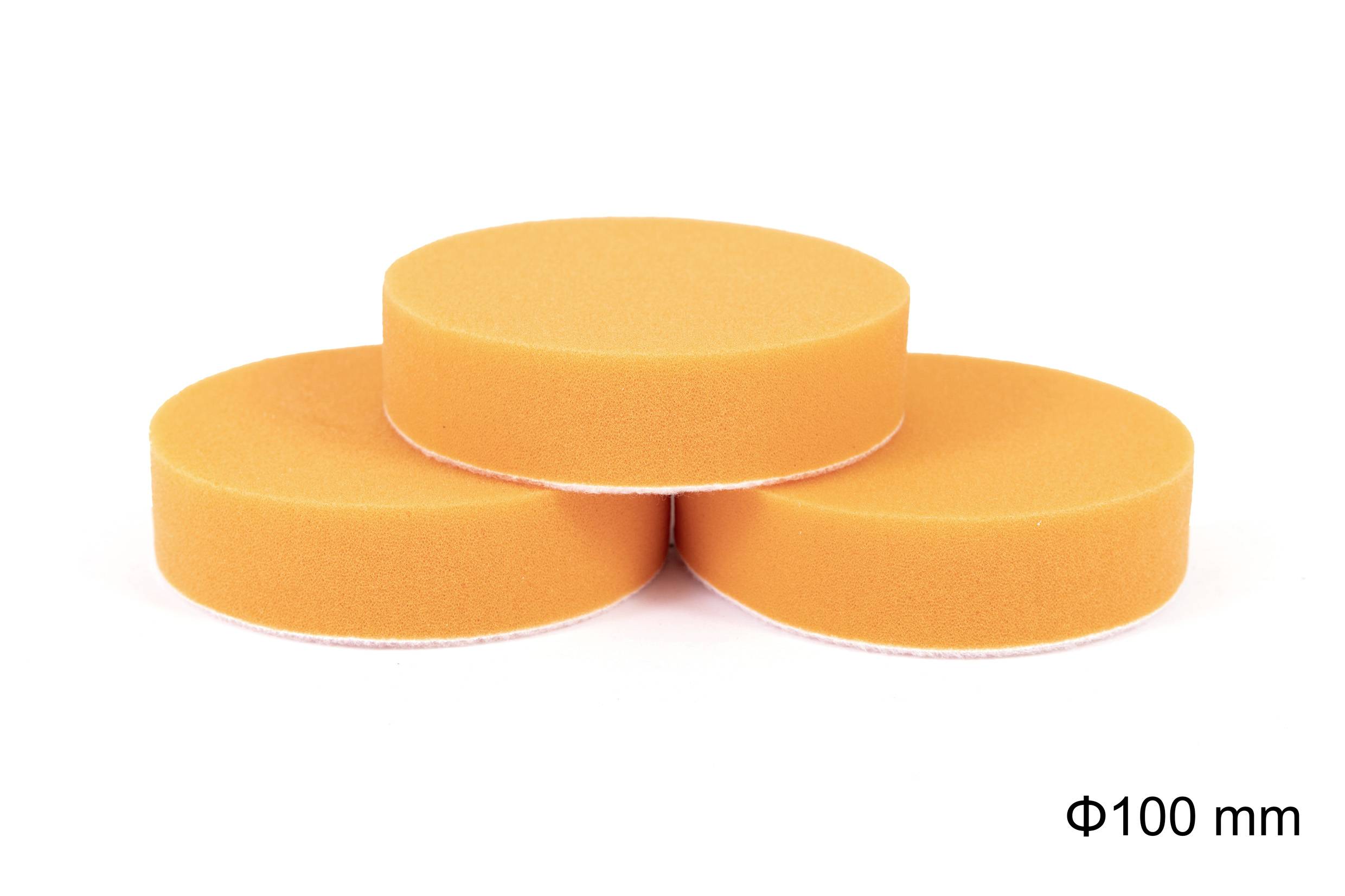 Drei orangefarbene runde Schwämme mit einem Durchmesser von 100 mm, gestapelt im Dreieck auf weißem Hintergrund.