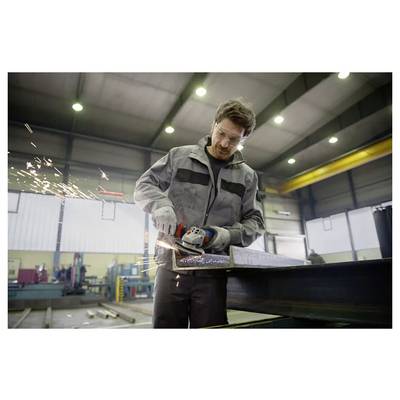 Ein Fabrikarbeiter in Schutzausrüstung benutzt ein Elektrowerkzeug, um ein Metallstück in einer Industriewerkstatt zu schleifen, wobei Funken fliegen.