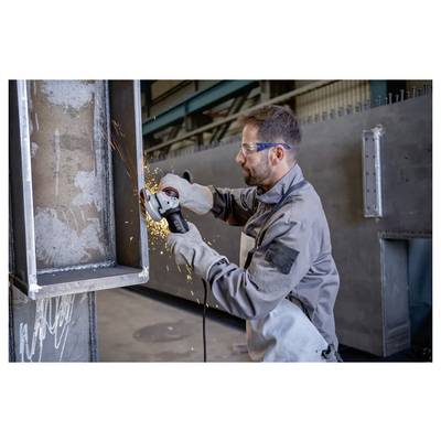 Ein Arbeiter in Schutzausrüstung verwendet eine Winkelschleifer zum Schneiden von Metall, wobei Funken sprühen, in einer industriellen Umgebung.