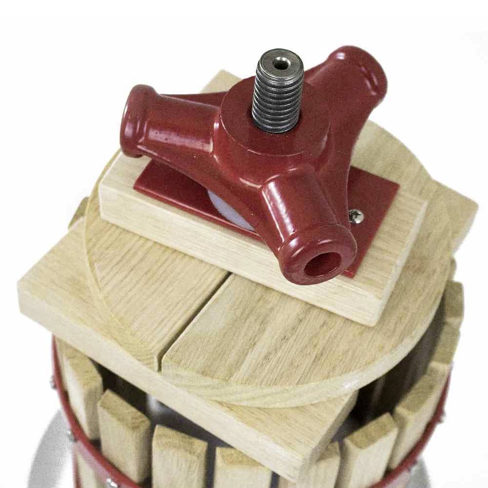 Ein roter Metallgriff auf einem hölzernen Pressmechanismus, vermutlich Teil einer Obst- oder Weinpresse.