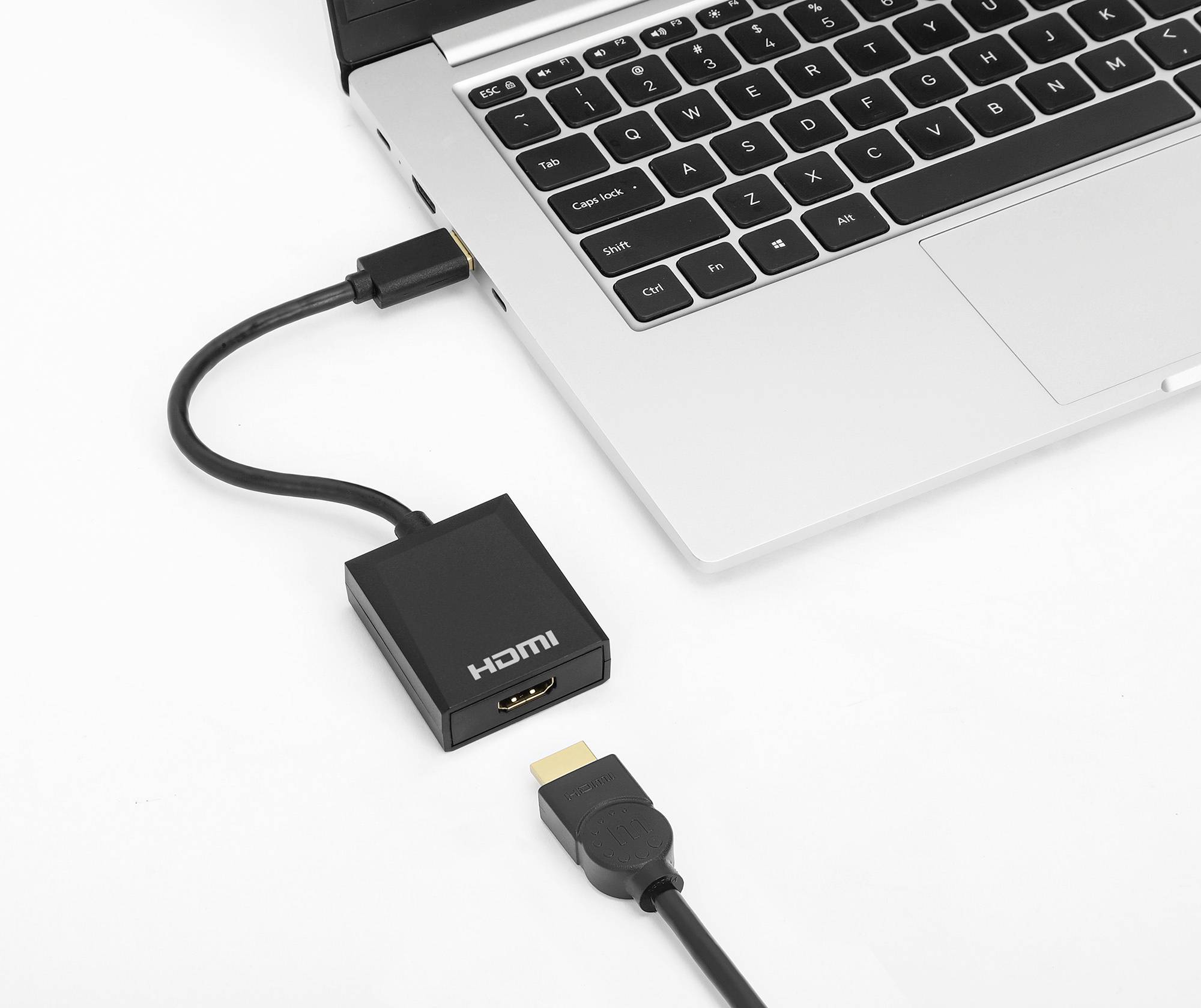 Ein Laptop mit einem HDMI-Kabel verbunden, das an einen HDMI-Adapter angeschlossen ist. Adapter und zweites HDMI-Steckerende sichtbar.