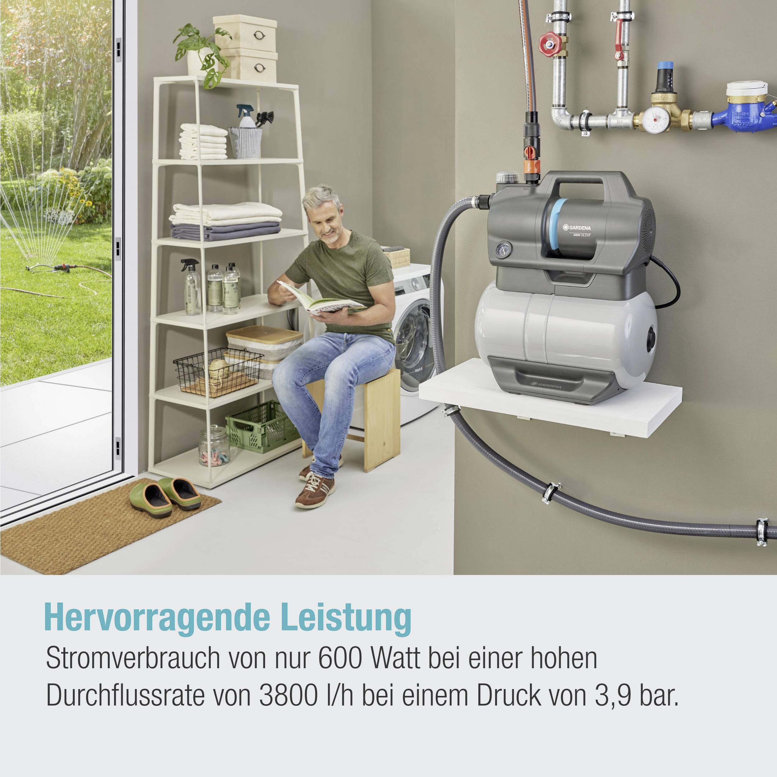 Ein Mann sitzt in einem Technikraum, studiert ein Tablet. Auf einem Regal liegen Werkzeuge. Neben ihm steht eine moderne Wasserpumpe.