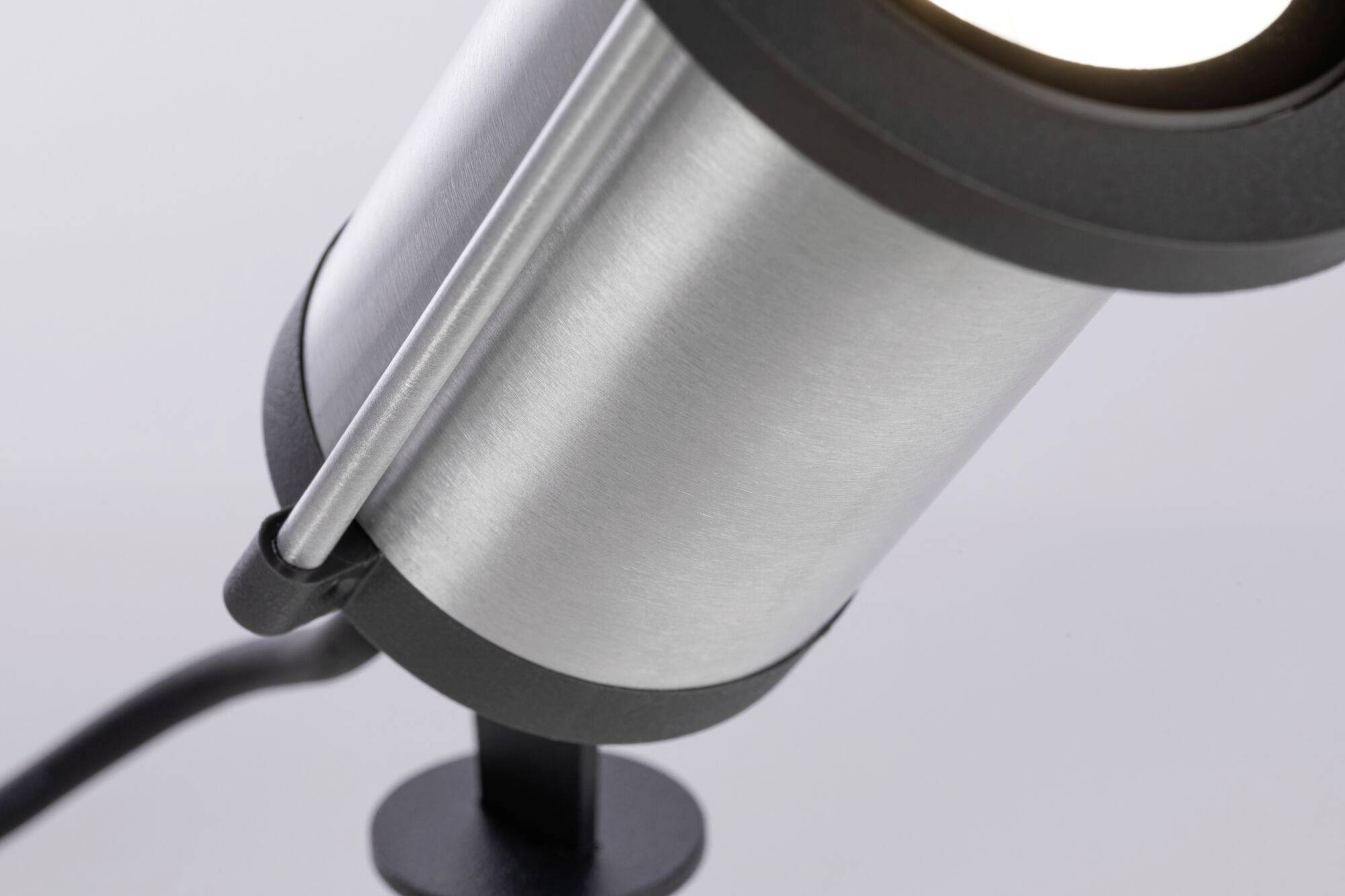 Metalllampe mit modernem Design, schräg nach unten gerichtet, schwarzer Sockel, geeignet für zielgerichtete Beleuchtung.