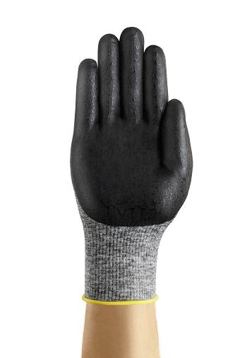 Schwarzer Handschuh an einer Hand getragen, grauer Stoff am Handgelenk, gelber Rand am Ende.