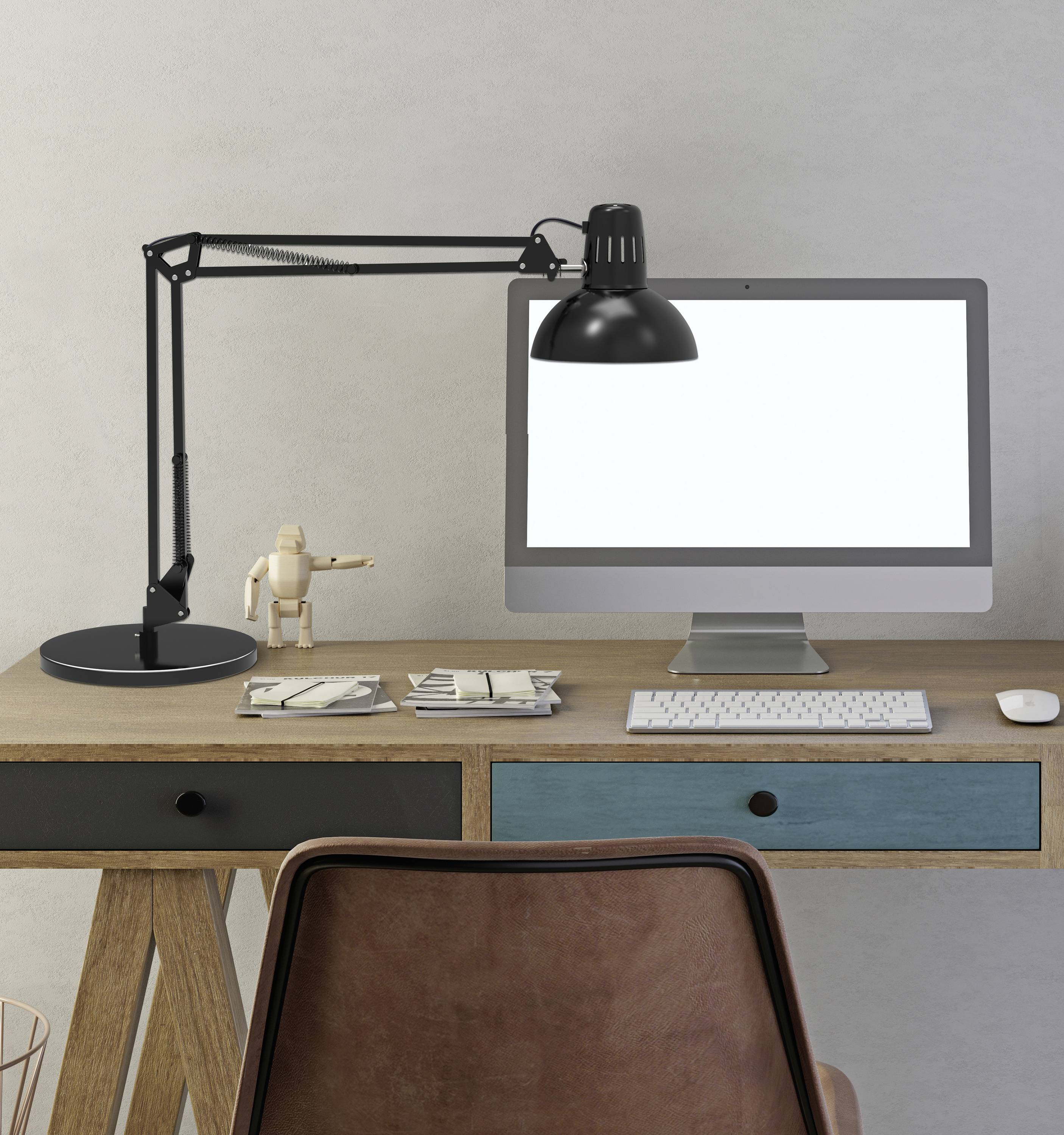Ein Schreibtisch mit Lampe, Computer, Tastatur und Notizbüchern. Daneben steht eine kleine Holzfigur. Minimalistischer Arbeitsplatz.