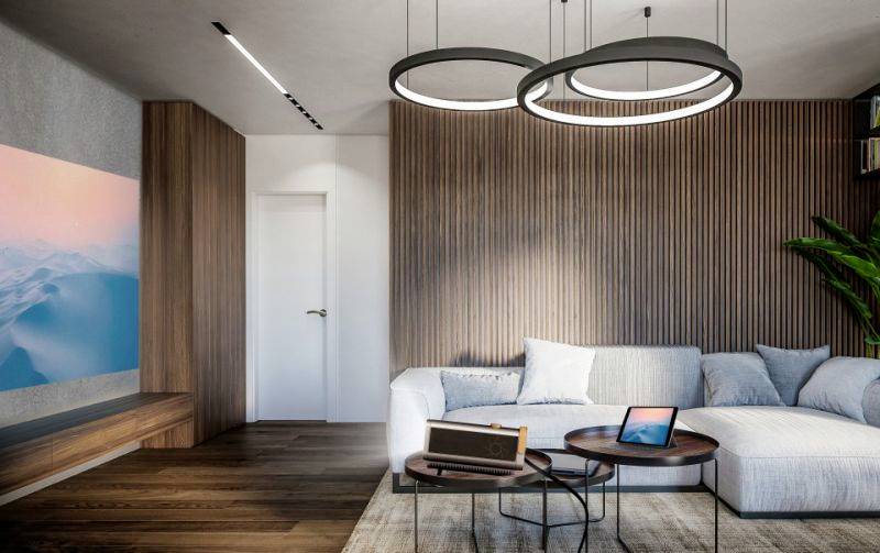 Modernes Wohnzimmer mit weißem Sofa, zwei runden Couchtischen, Laptop und Radio. An der Wand hängt ein großes Bild mit Berglandschaft.