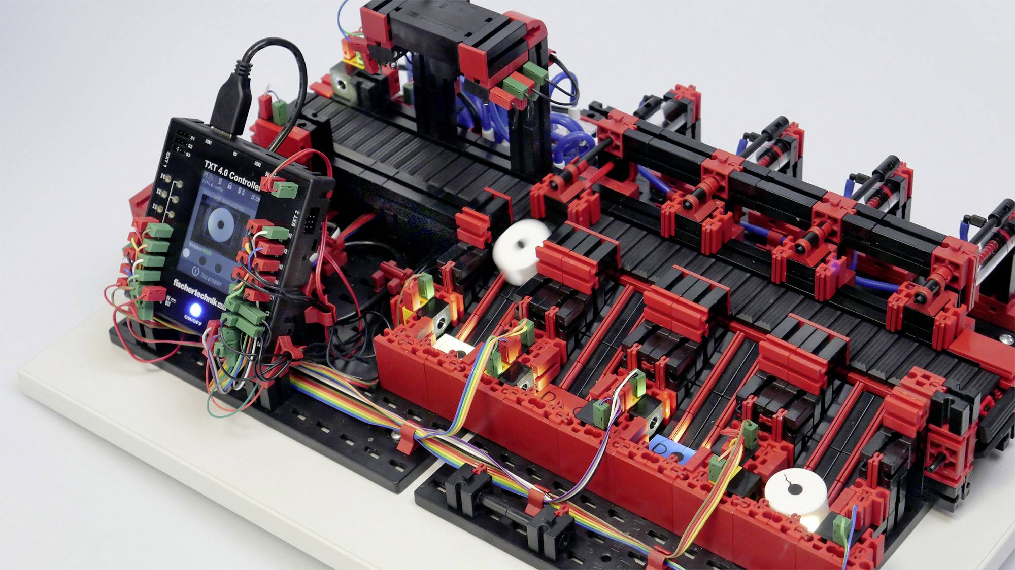 Ein DIY-Plotter aus LEGO und Elektronikkomponenten zeichnet auf Papier. Ein Smartphone steuert den Mechanismus.