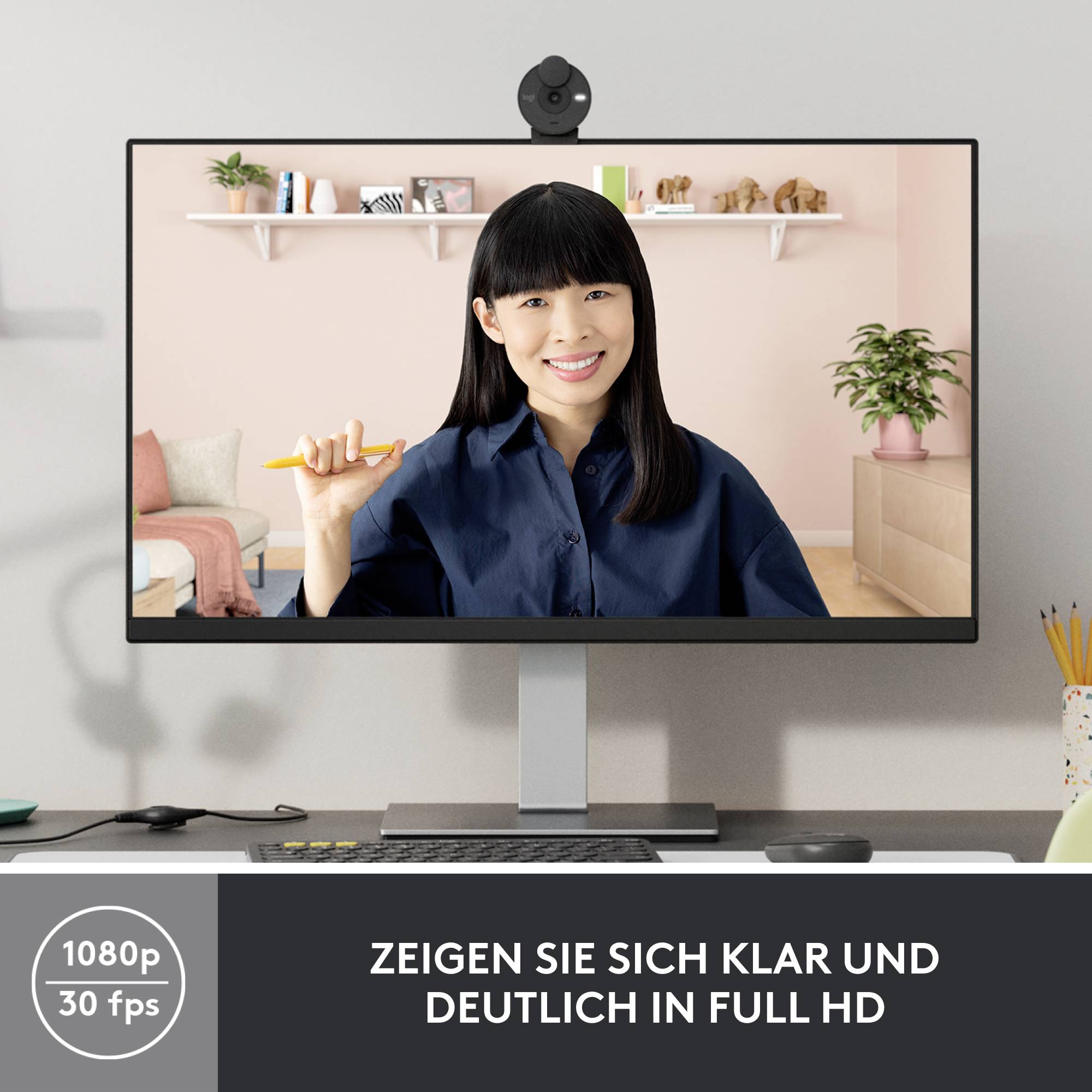 Eine lächelnde Frau hält eine orange Zahnbürste, sitzt vor einem Schreibtisch mit einem Computerbildschirm. Text: 'Zeigen Sie sich klar und deutlich in Full HD'.