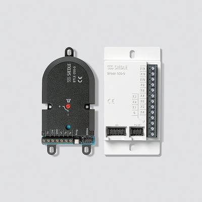 'Elektronisches Modul mit schwarzer und weißer Abdeckung, mehreren Anschlusspunkten und Etiketten.'