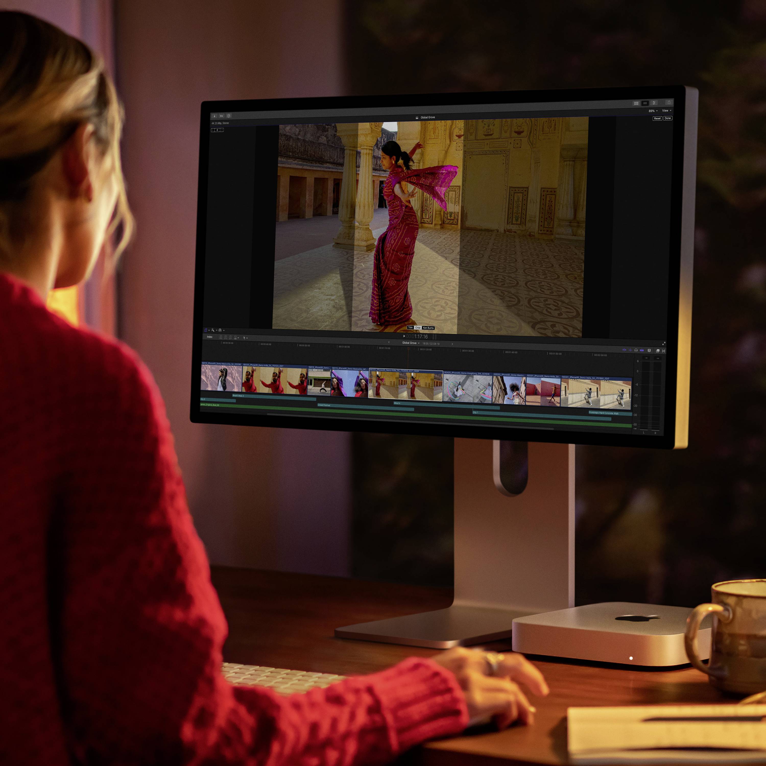 Eine Person sitzt an einem Schreibtisch und bearbeitet ein Foto auf einem Computerbildschirm. Die Umgebung wirkt warm und gemütlich.