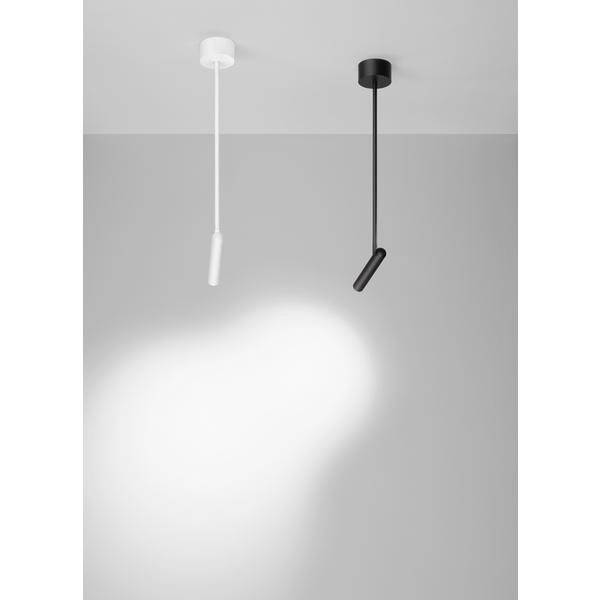 Zwei minimalistische Deckenleuchten, eine weiß, eine schwarz, leuchten von oben auf eine graue Wand und den Boden darunter.