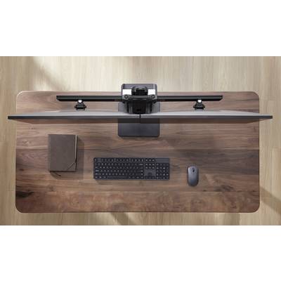 Ein Schreibtisch aus Holz mit einem geschlossenen Laptop, einer Tastatur und einer Maus von oben gesehen.