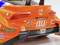 Spielzeugauto in Orange, Nachbildung eines Rennwagens. Die Rückseite zeigt Markenlogos und Startnummer 36.