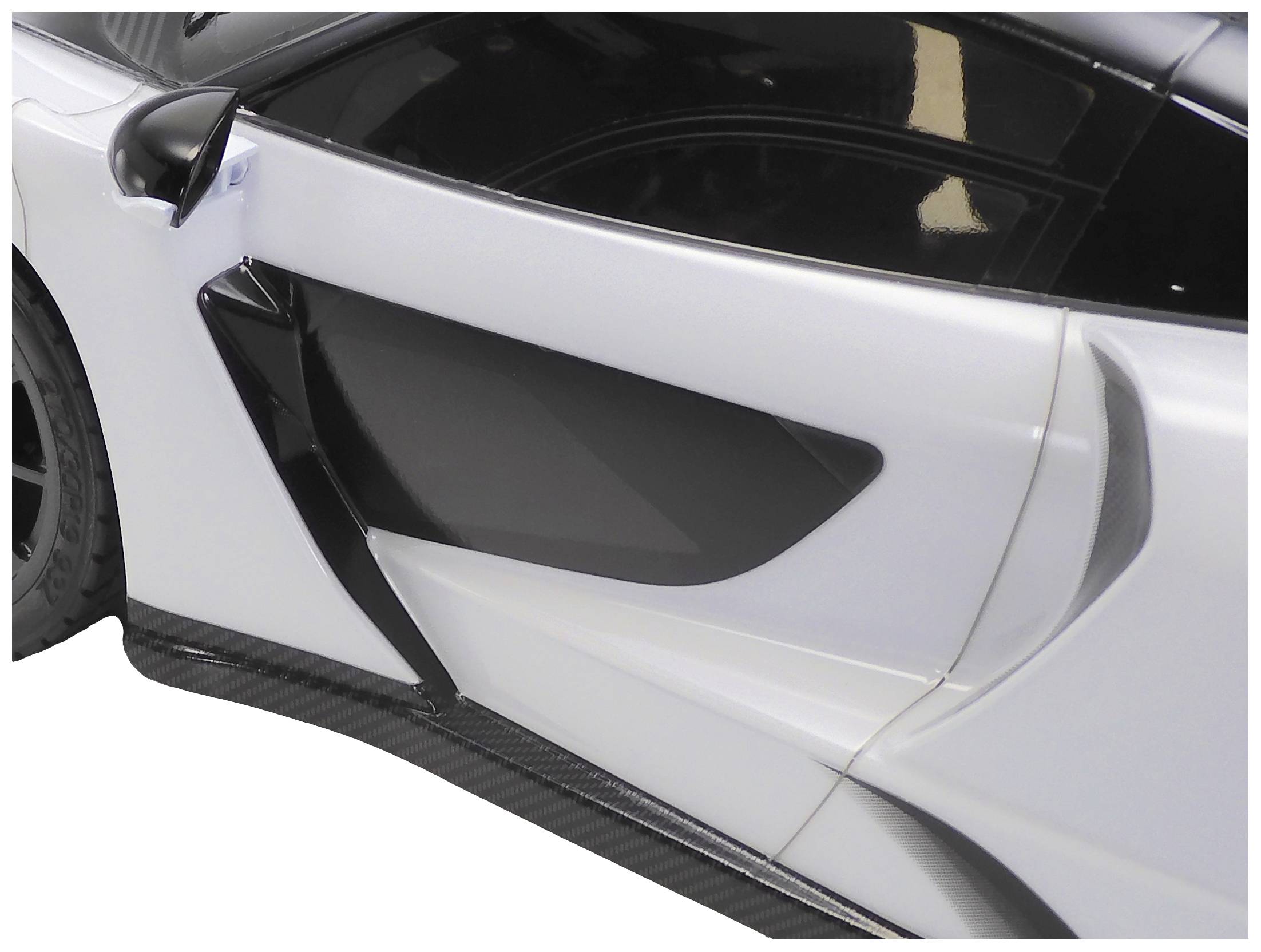 Detailansicht eines Autos mit schwarzem und weißem Lack, fokussiert auf die Tür und den Seitenspiegel. Hochwertige Sportwagenoptik.