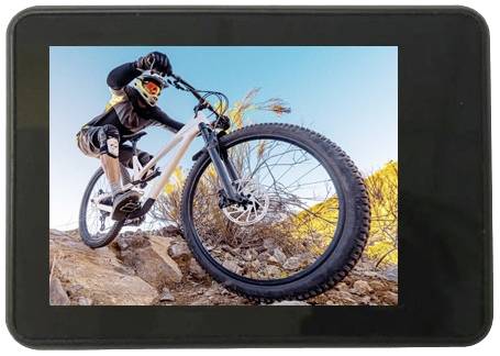 Eine Person fährt mit einem Mountainbike auf felsigem Gelände bergab, unter einem klaren, blauen Himmel.