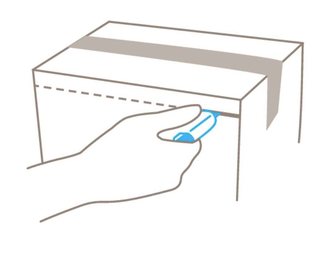 Hand öffnet eine Kartonklappe mit einem blauen Werkzeug.