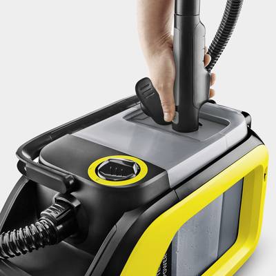 Eine Hand hält einen Dampfreiniger mit gelbem Gehäuse und transparentem Wassertank.