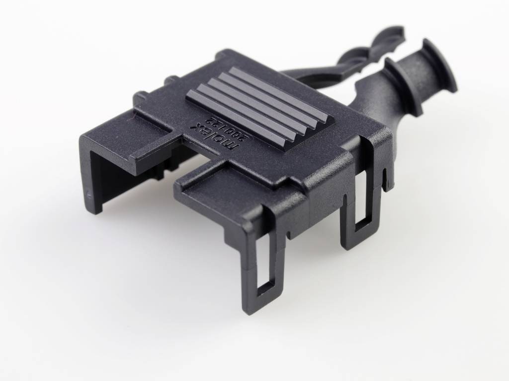 Ein schwarzes Kunststoff-Bauteil mit Haken und Rillen. Es könnte für den Einsatz in einem technischen oder mechanischen Kontext bestimmt sein.