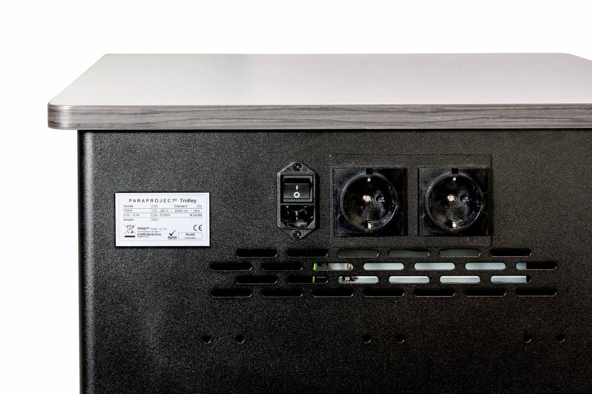 Rückansicht eines elektronischen Geräts mit zwei Steckdosen und einem Netzschalter. Ein Etikett mit Modellnummer ist sichtbar.