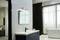 Modernes Badezimmer mit wandmontiertem Waschbecken, beleuchtetem Spiegel und freistehender Badewanne vor einem großen Fenster.