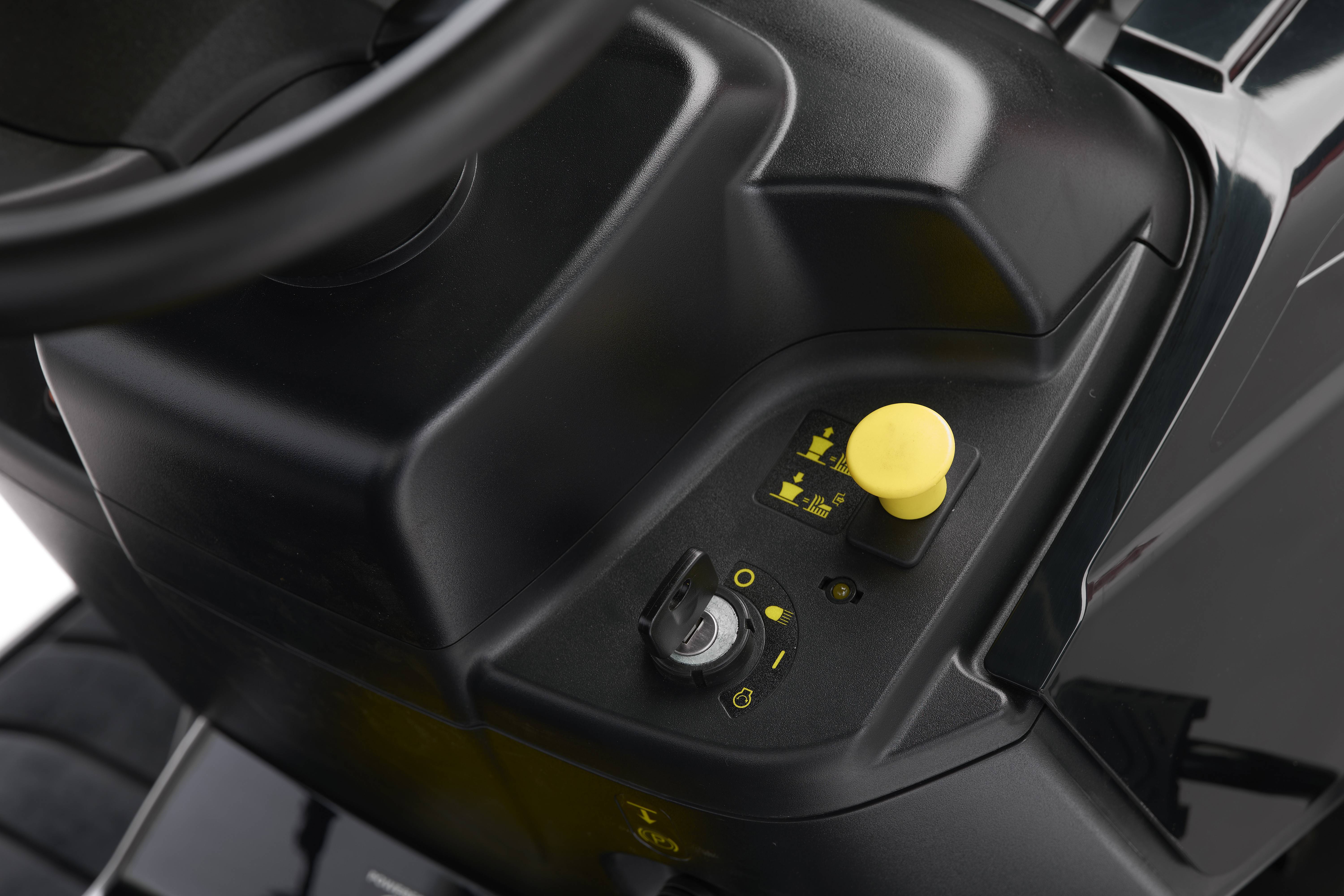 Close-up von einem schwarzen Armaturenbrett mit einem gelben Bedienknopf und einem Schalter-System, das Funktionen eines Fahrzeugs steuert.