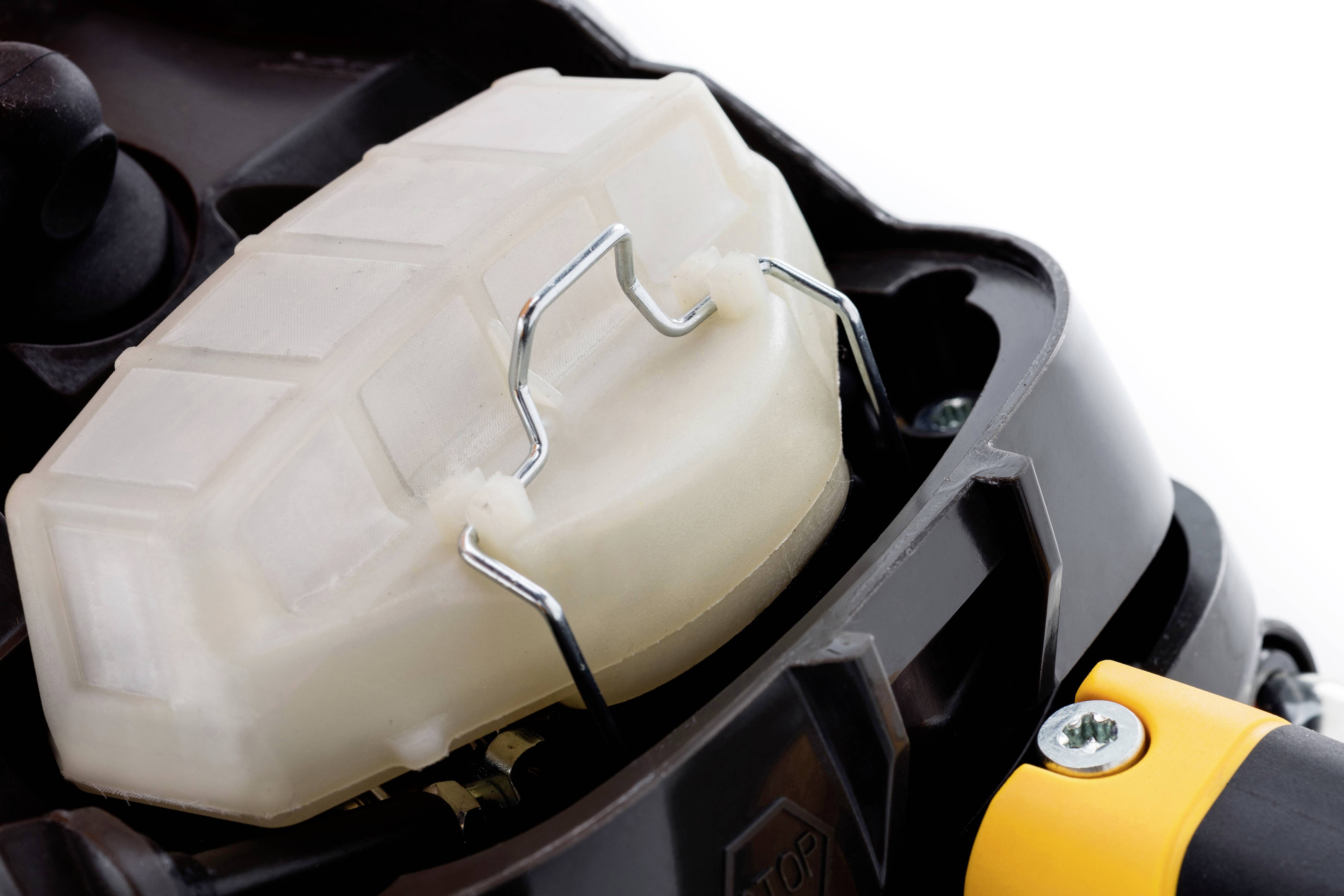 Luftfilter auf einem Rasenmähermotor, schwarz-gelber Rahmen.