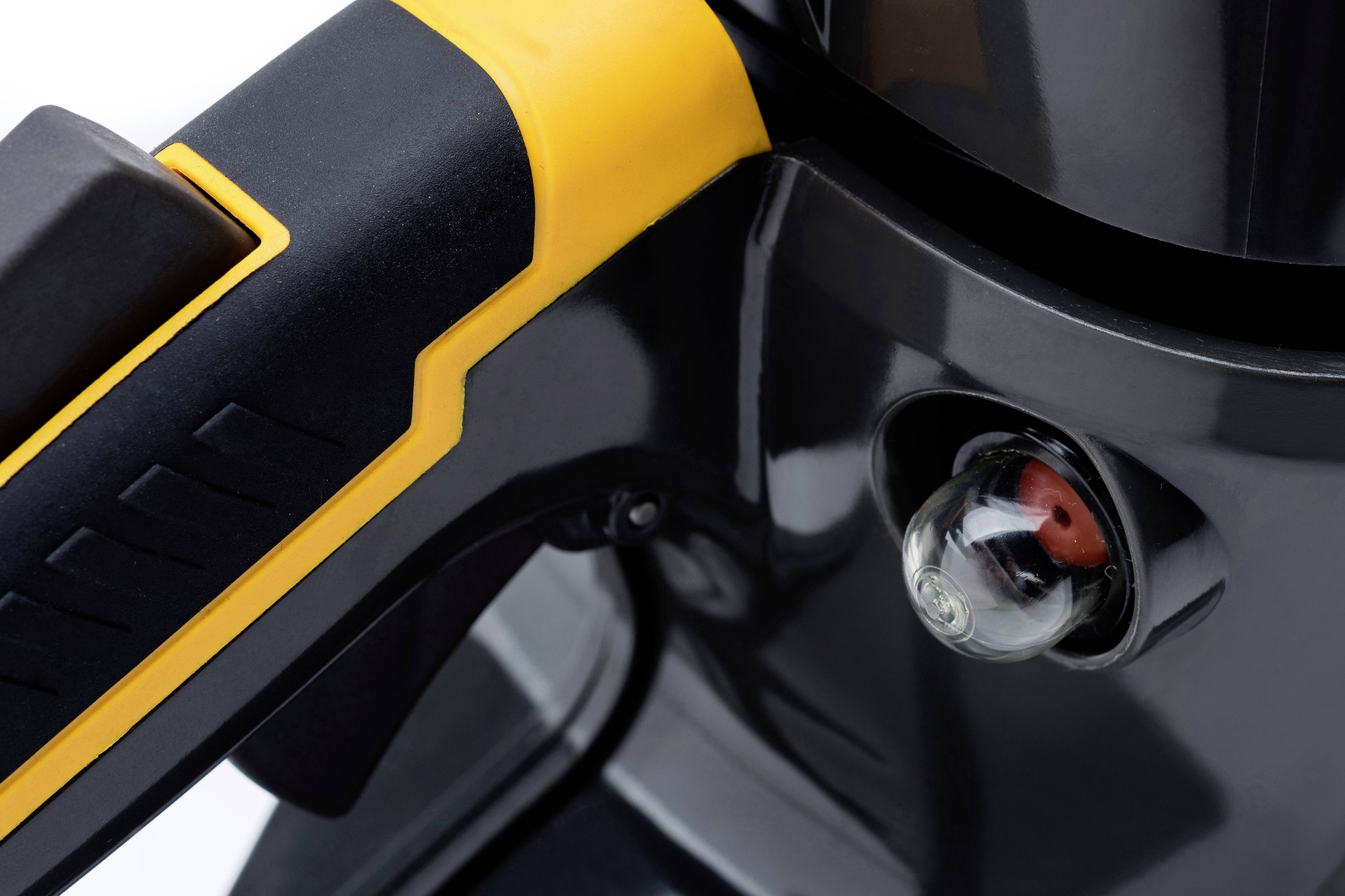 Nahaufnahme eines grauen Geräts mit gelben und schwarzen Details, das einen Druckknopf und eine klare Anzeige mit einem roten Punkt enthält.