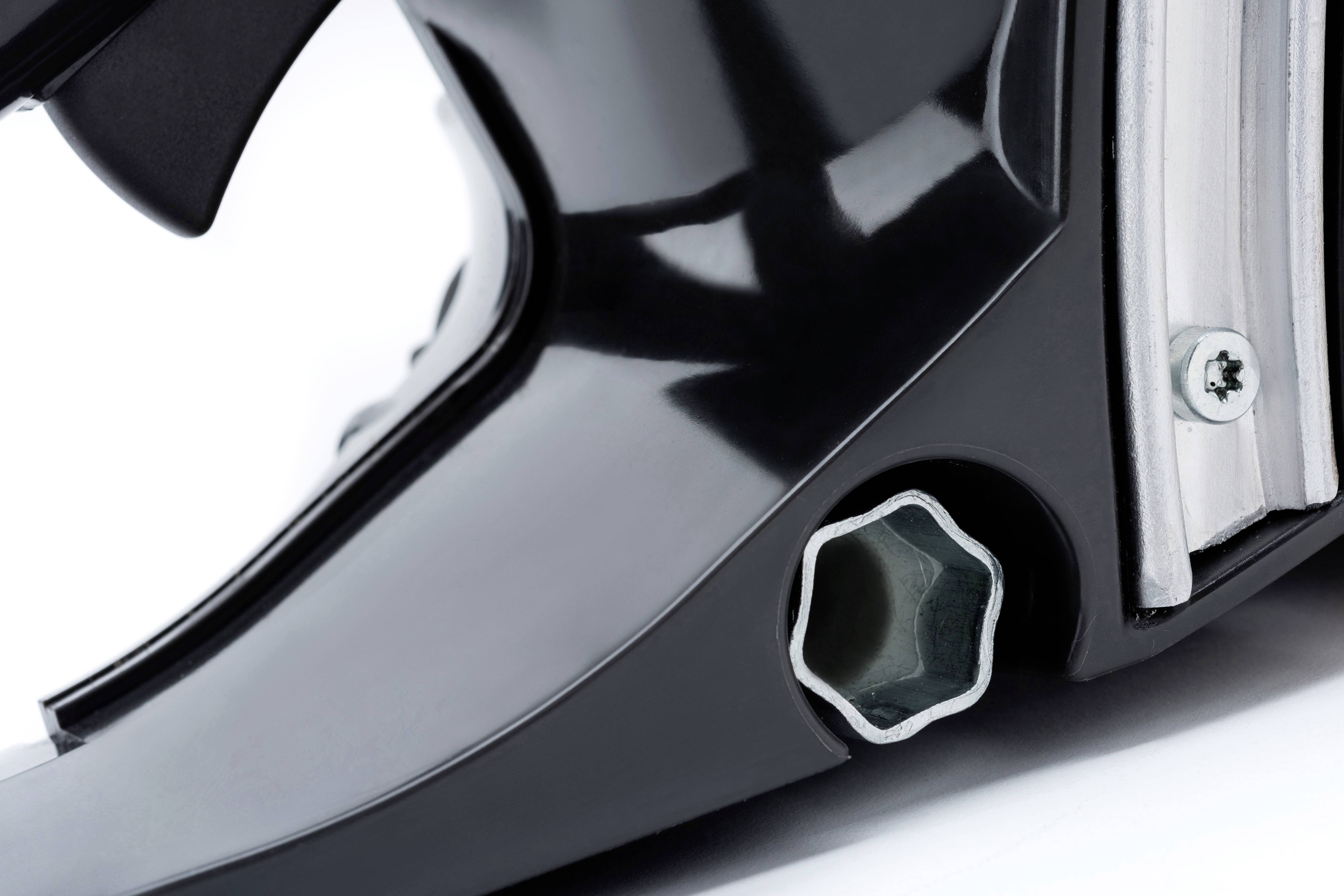 Nahaufnahme eines schwarzen Gehäuseteils mit metallischem Sechskantanschluss und Schraube rechts. Fokus auf Textur und Design.