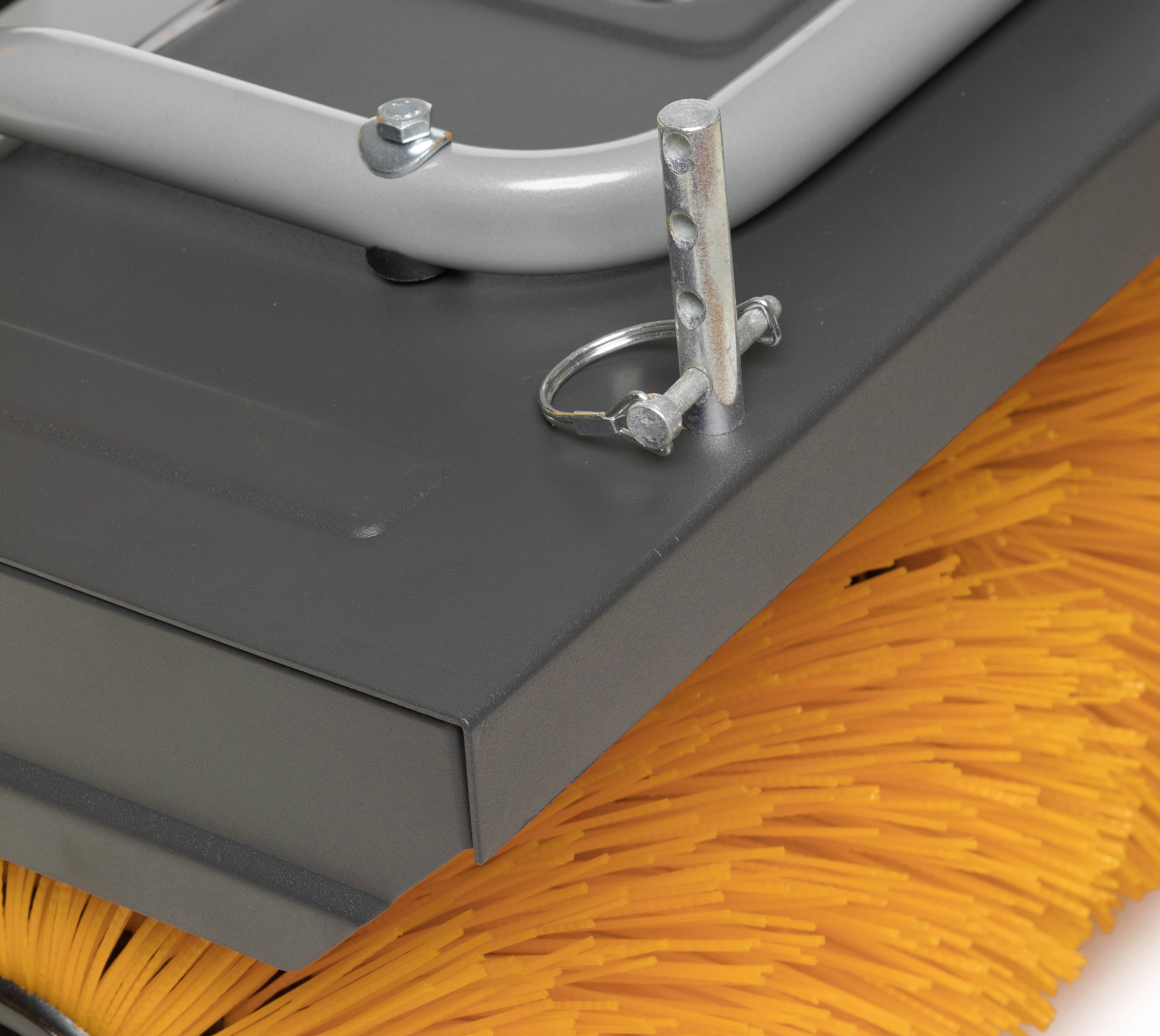 Nahaufnahme einer Kehrmaschine mit rotierenden gelben Borsten und einem stabilen grauen Metallgehäuse. Werkzeug und Halterung sind sichtbar.