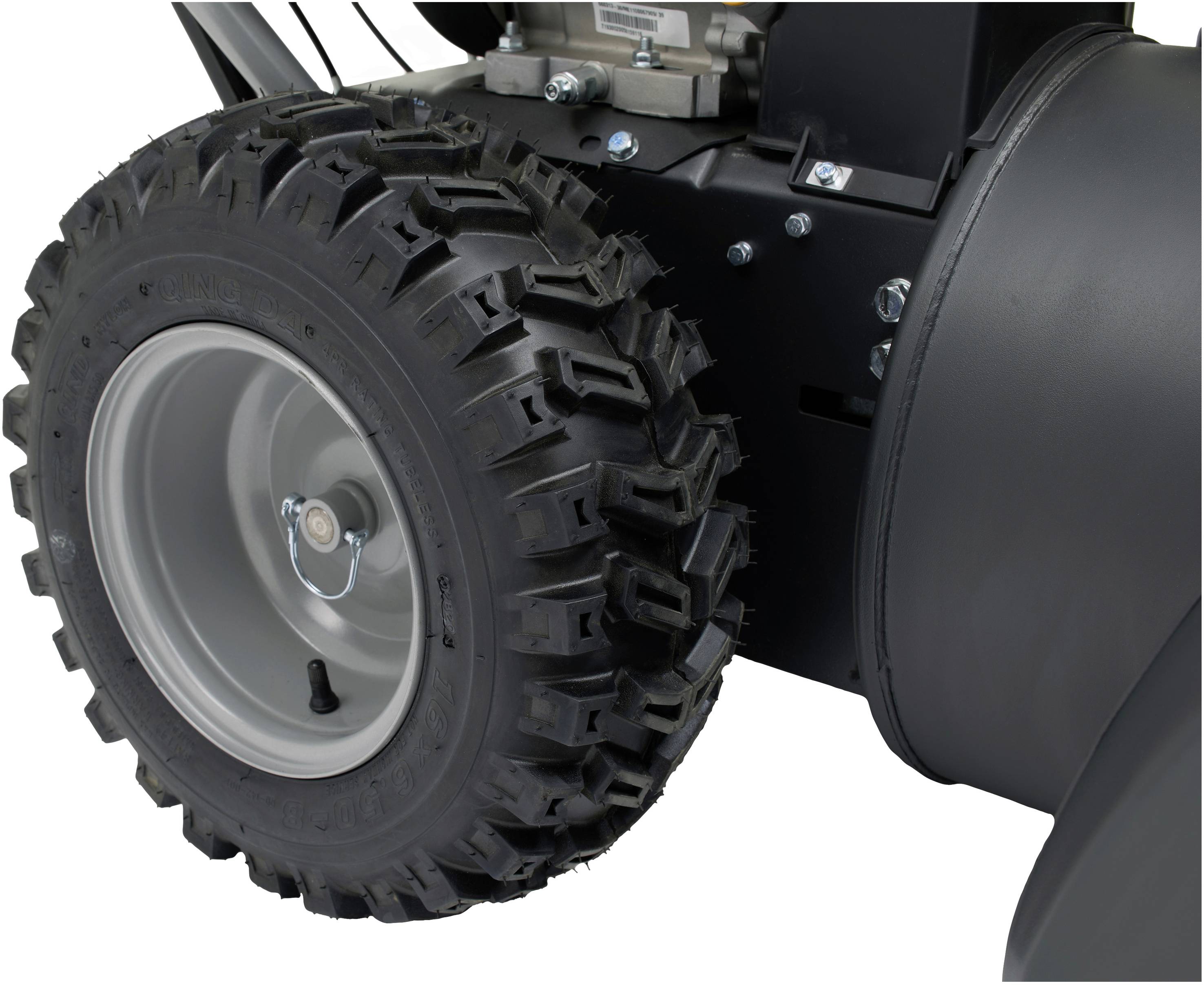Großaufnahme eines Reifens mit grobem Profil an einem mechanischen Gerät. Zeigt Details der Radaufhängung und Befestigungen.