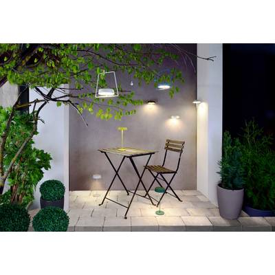 Gemütlich gestaltete Terrasse mit Klappstuhl und -tisch, umgeben von grünen Pflanzen und moderner Beleuchtung an einer grauen Wand.