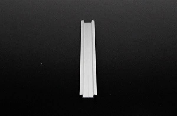 'Mittelgroße, weiße Kunststoffschiene auf schwarzem Hintergrund'