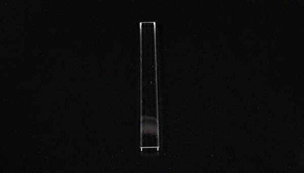 Ein einzelnes durchsichtiges rechteckiges Prisma in der Mitte eines schwarzen Hintergrunds.