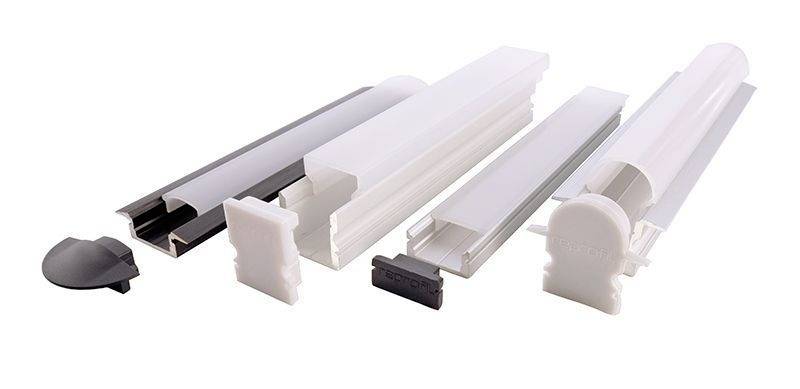 Verschiedene weiße und transparente LED-Profilabdeckungen und Endkappen in unterschiedlichen Formen und Größen, nebeneinander liegend.