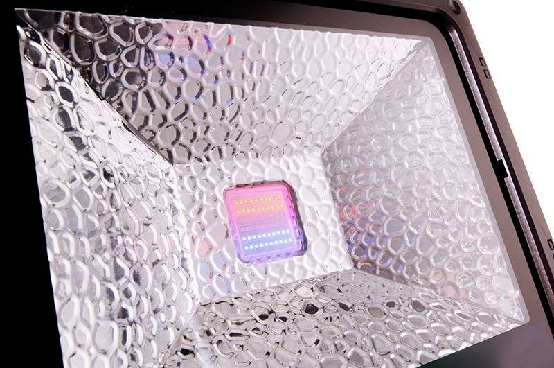 Nahaufnahme eines LED-Lichts in einem reflektierenden Gehäuse mit Textur, das eine Vielzahl von Farben ausstrahlt.