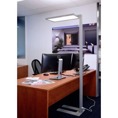 Moderner Büroraum mit Holzschreibtisch, PC, Telefon und Stehlampe. An der Wand hängt ein Bild eines beleuchteten Hauses bei Nacht.