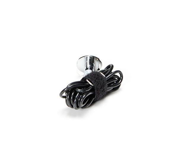Ein zusammengewickeltes schwarzes Kabel, gehalten mit einem Klettverschluss, liegt neben einem silbernen Befestigungselement auf weißem Hintergrund.