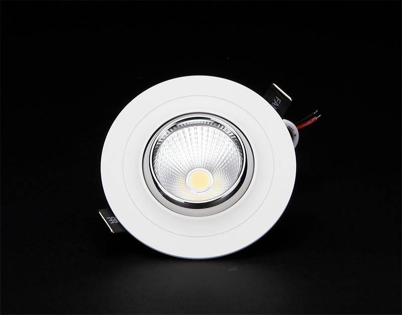 Einbau-LED-Spotlight mit kreisförmigem Rahmen, zentrale LED-Leuchte und zwei Halteklammern auf schwarzem Hintergrund.