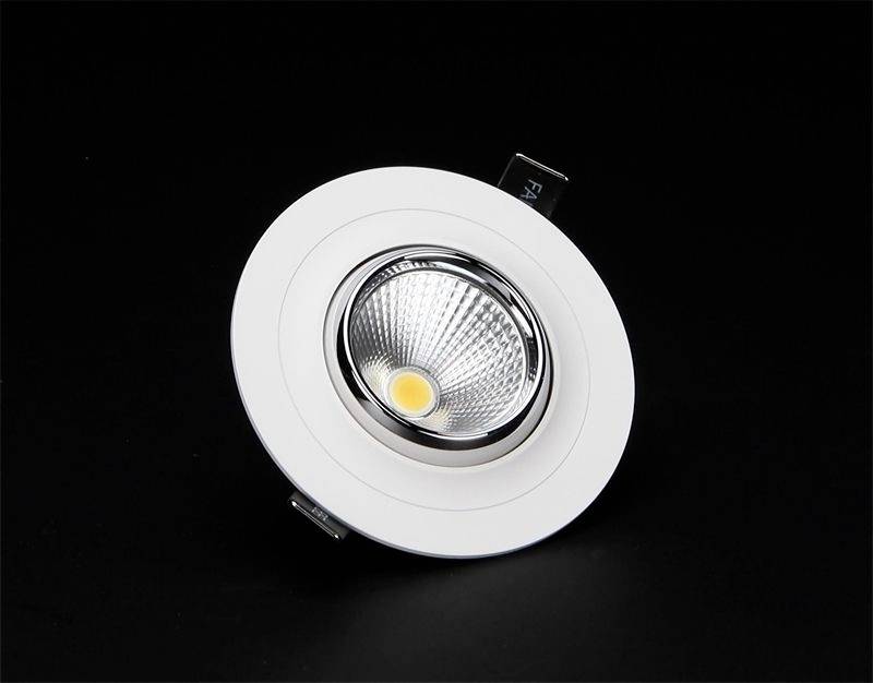 Rundes LED-Einbaulicht mit weißem Rand und reflektierender Innenseite auf schwarzem Hintergrund, von oben gesehen.
